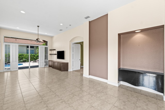 6346 San Michel Way, Delray Beach, FL 33484 - unfurnished living room featuring light tile patterned floors, arched walkways, baseboards, visible vents, and recessed lighting