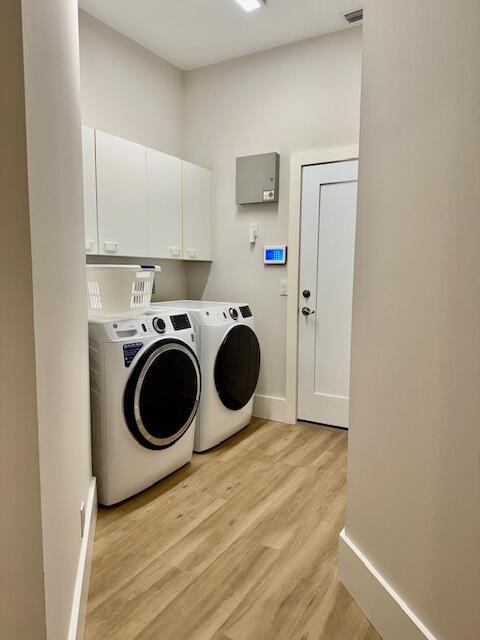 12624 Mallet Cir, Wellington, FL 33414 - laundry room featuring baseboards, washing machine and clothes dryer, light wood-type flooring, and cabinet space
