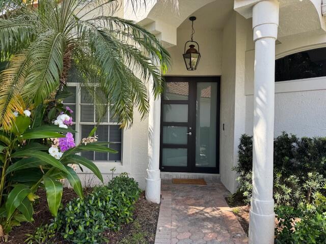 12624 Mallet Cir, Wellington, FL 33414 - view of exterior entry featuring stucco siding and french doors
