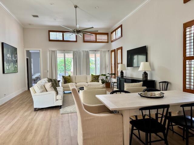 12624 Mallet Cir, Wellington, FL 33414 - living area with a ceiling fan, crown molding, a high ceiling, light wood-style flooring, and baseboards