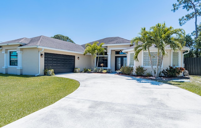 view of front facade featuring a front yard, a garage, fence, stucco siding, and driveway