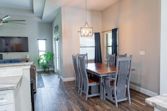 dining room featuring ceiling fan with notable chandelier, baseboards, and dark wood finished floors
