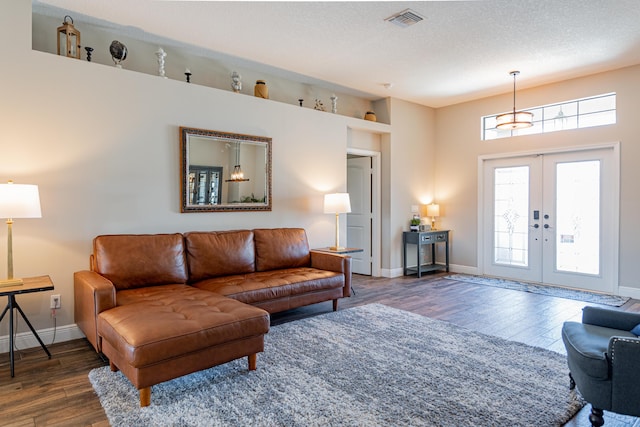living area with visible vents, baseboards, french doors, and wood finished floors