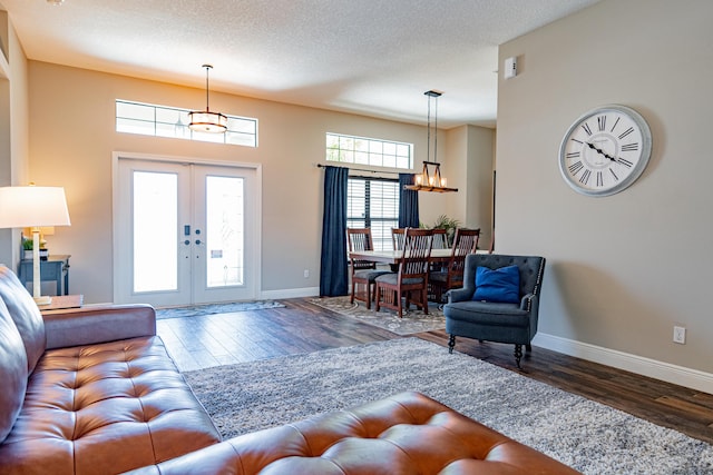 living area with a healthy amount of sunlight, an inviting chandelier, and wood finished floors