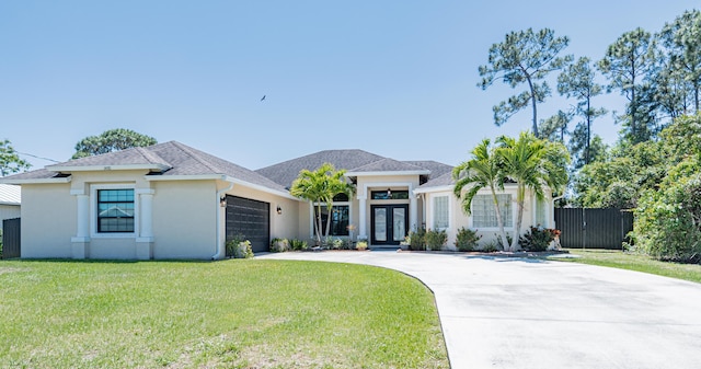 prairie-style home featuring stucco siding, a front lawn, an attached garage, french doors, and concrete driveway