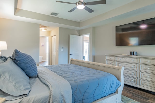 bedroom featuring dark wood-style flooring, ceiling fan, ensuite bathroom, and visible vents