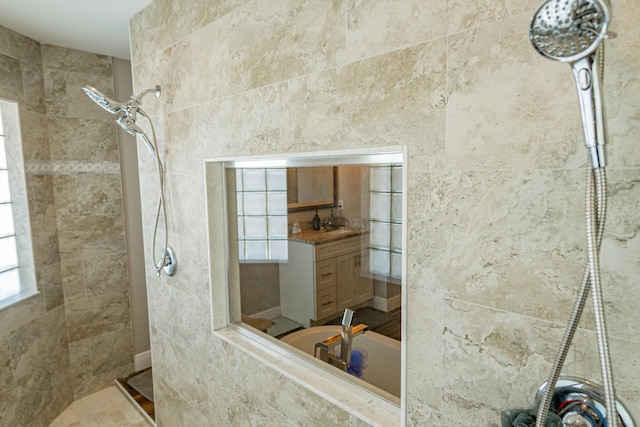 full bath featuring tile walls, walk in shower, and vanity