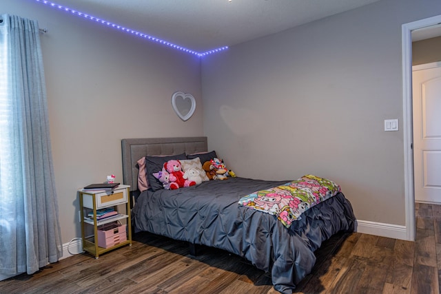 bedroom with baseboards and wood finished floors