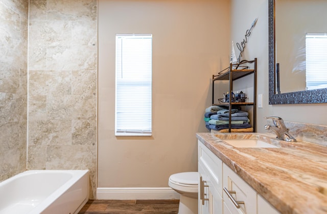 bathroom with vanity, baseboards, toilet, and wood finished floors