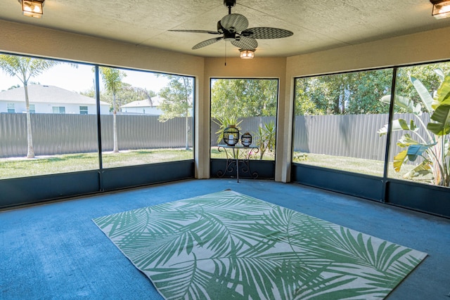 unfurnished sunroom with ceiling fan