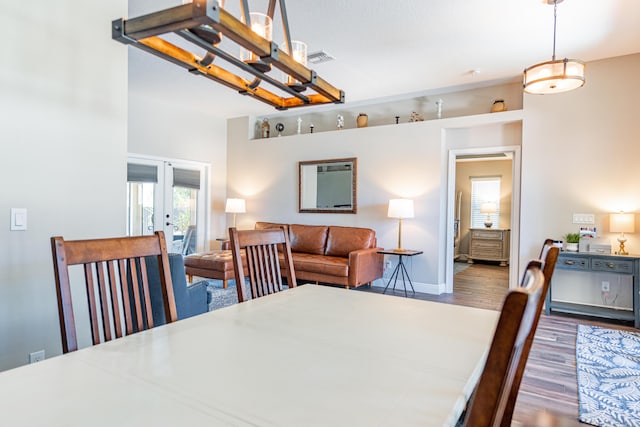 dining area featuring french doors, baseboards, wood finished floors, and a healthy amount of sunlight