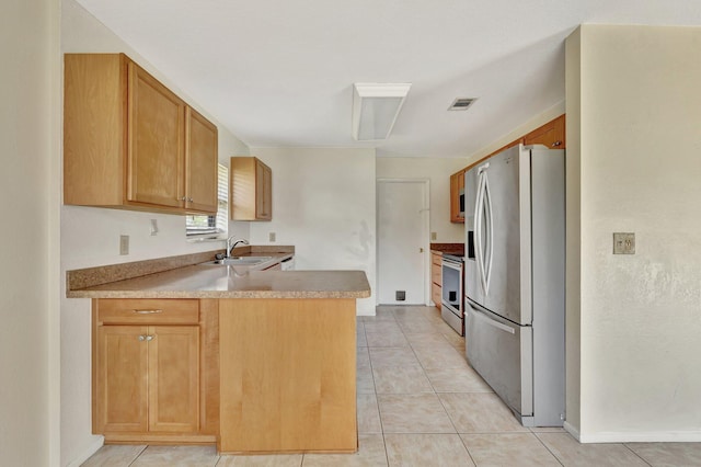 kitchen featuring a sink, stainless steel fridge with ice dispenser, range, a peninsula, and visible vents