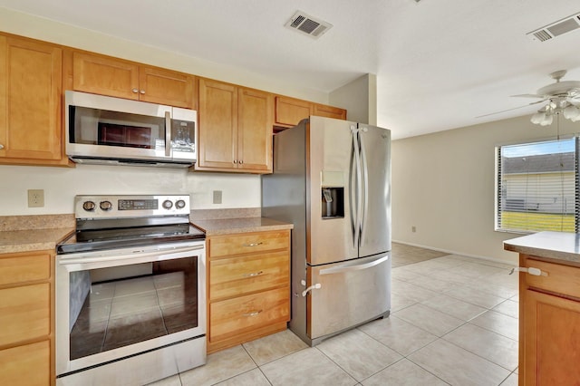 kitchen featuring a ceiling fan, appliances with stainless steel finishes, visible vents, and light tile patterned floors