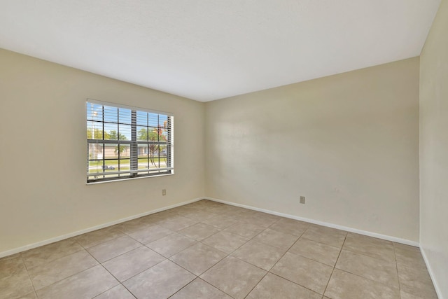 spare room featuring baseboards and light tile patterned flooring