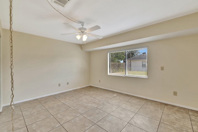 spare room with visible vents, a ceiling fan, baseboards, and light tile patterned floors