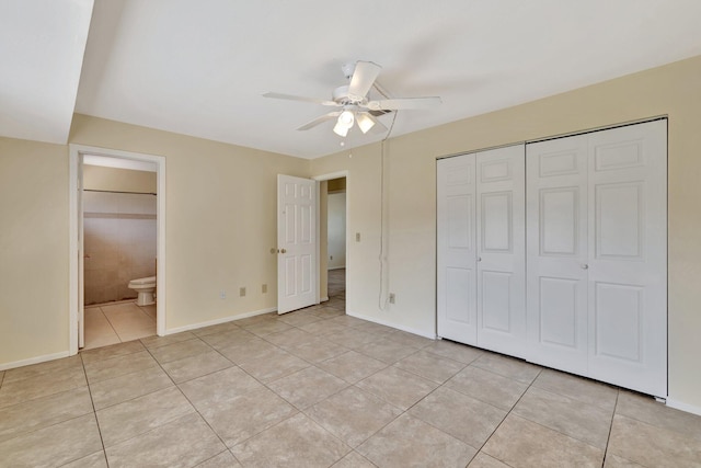 unfurnished bedroom featuring ceiling fan, light tile patterned floors, a closet, baseboards, and ensuite bathroom