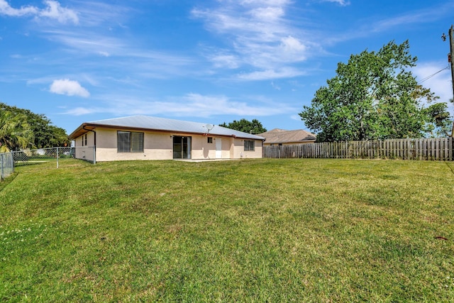 back of property with a lawn, a fenced backyard, and stucco siding