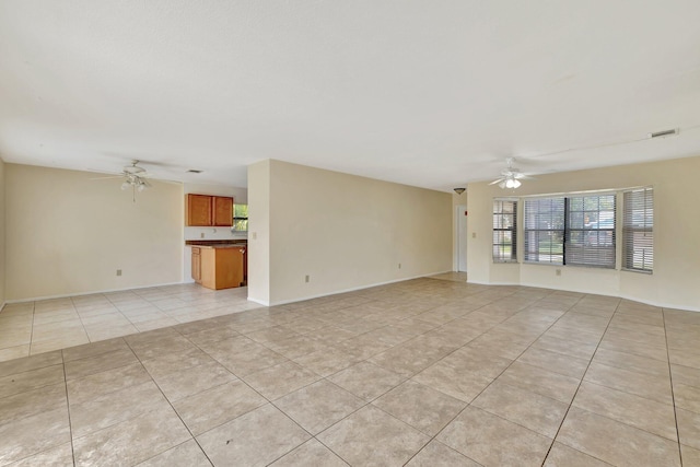 unfurnished living room with visible vents, baseboards, ceiling fan, and light tile patterned floors