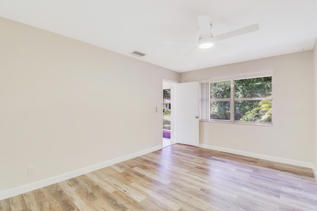 spare room with visible vents, a ceiling fan, light wood-style floors, and baseboards
