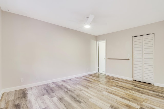unfurnished bedroom featuring baseboards, ceiling fan, a closet, and light wood-type flooring
