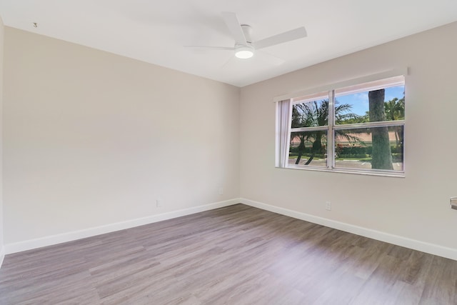 empty room featuring baseboards, ceiling fan, and wood finished floors
