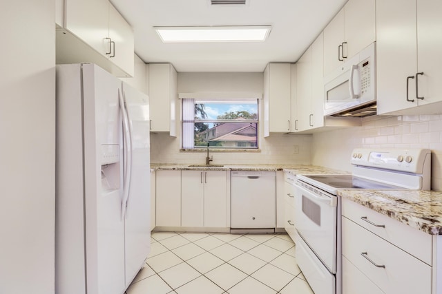 kitchen with visible vents, white appliances, tasteful backsplash, a sink, and light tile patterned floors
