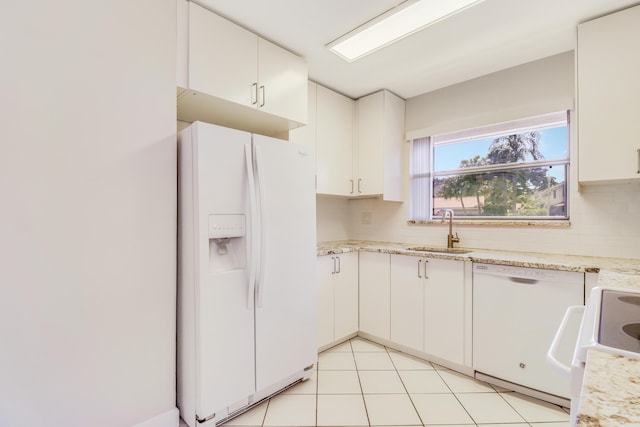 kitchen featuring white appliances, light tile patterned flooring, white cabinets, and a sink