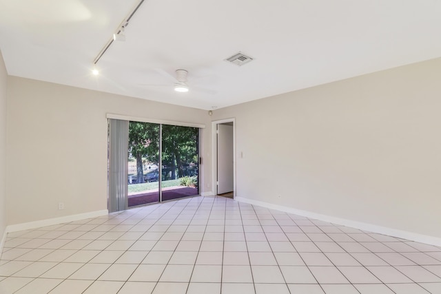 spare room featuring visible vents, rail lighting, baseboards, and ceiling fan