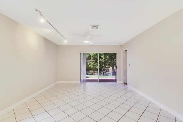 spare room featuring visible vents, baseboards, light tile patterned floors, and track lighting