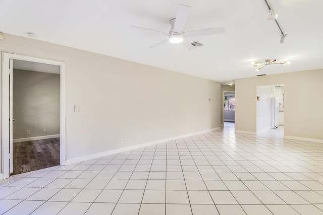 spare room with a ceiling fan, visible vents, track lighting, baseboards, and light tile patterned flooring