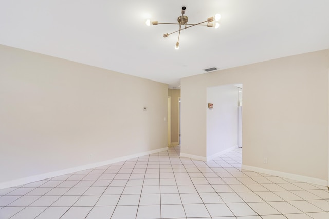 unfurnished room with an inviting chandelier, baseboards, and visible vents