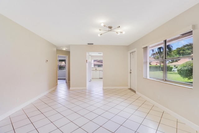 unfurnished room with baseboards, a notable chandelier, light tile patterned flooring, and visible vents