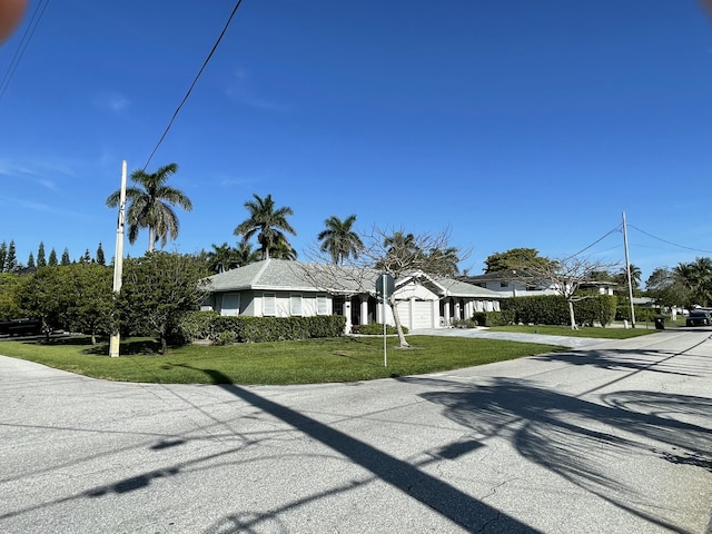 6401 NE 7th Ave, Boca Raton, FL 33487 - view of front of home featuring an attached garage, concrete driveway, and a front lawn