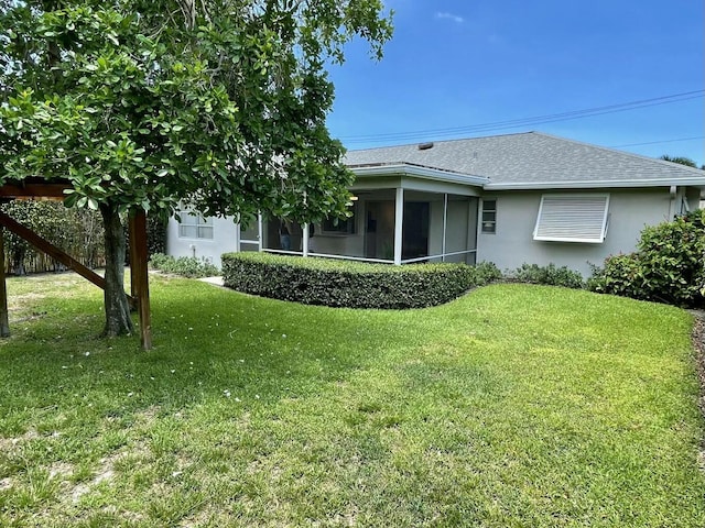 6401 NE 7th Ave, Boca Raton, FL 33487 - back of house featuring a lawn, roof with shingles, stucco siding, and a sunroom