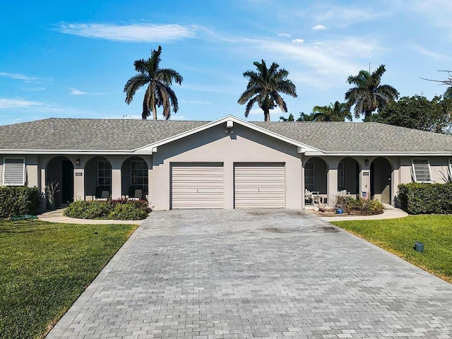 6401 NE 7th Ave, Boca Raton, FL 33487 - single story home with decorative driveway, an attached garage, a front lawn, and stucco siding