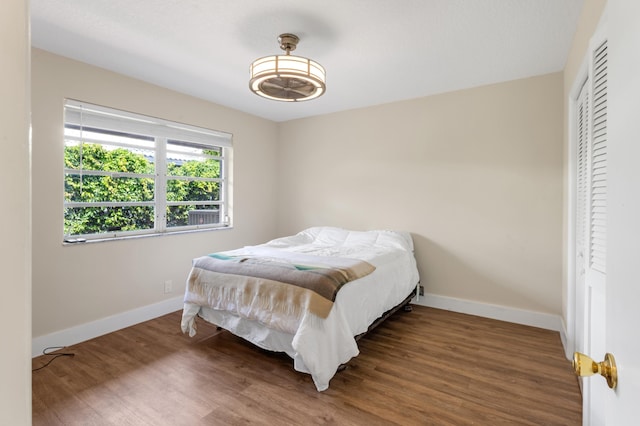 bedroom featuring a closet, baseboards, and wood finished floors