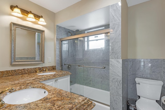 full bath featuring toilet, double vanity, and a sink
