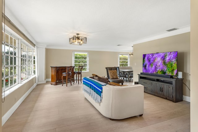 living room with visible vents, baseboards, an inviting chandelier, and light wood-style flooring