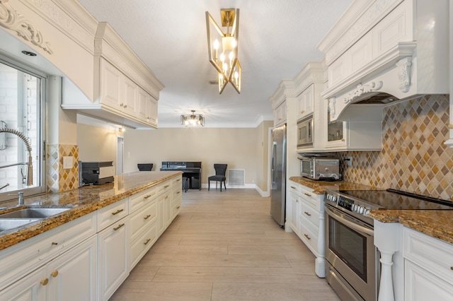 kitchen with tasteful backsplash, visible vents, dark stone countertops, a sink, and stainless steel appliances