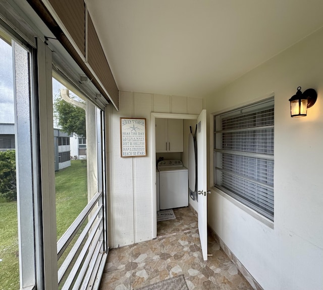 laundry room featuring baseboards, cabinet space, washer / clothes dryer, and stone finish floor