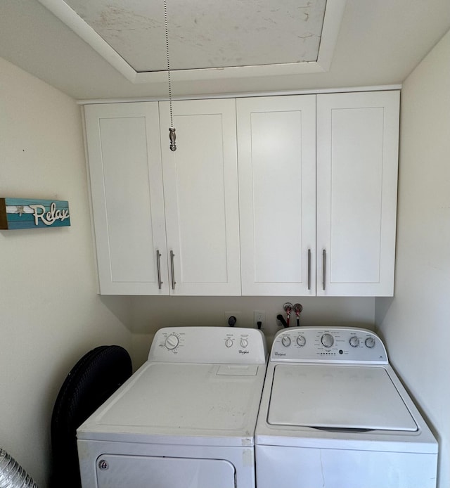 washroom featuring independent washer and dryer and cabinet space