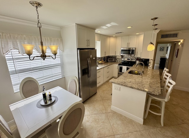 kitchen featuring a sink, appliances with stainless steel finishes, visible vents, decorative backsplash, and an inviting chandelier