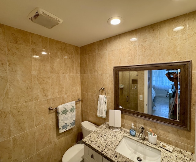 bathroom with vanity, tasteful backsplash, tile walls, toilet, and visible vents