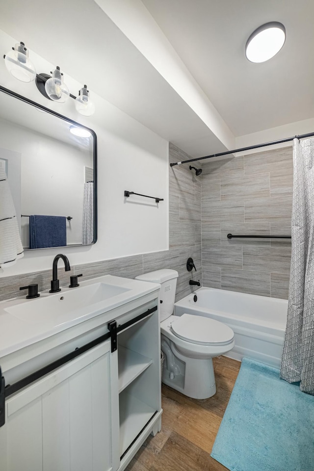 full bathroom with vanity, wood finished floors, toilet, tile walls, and shower / bath combo