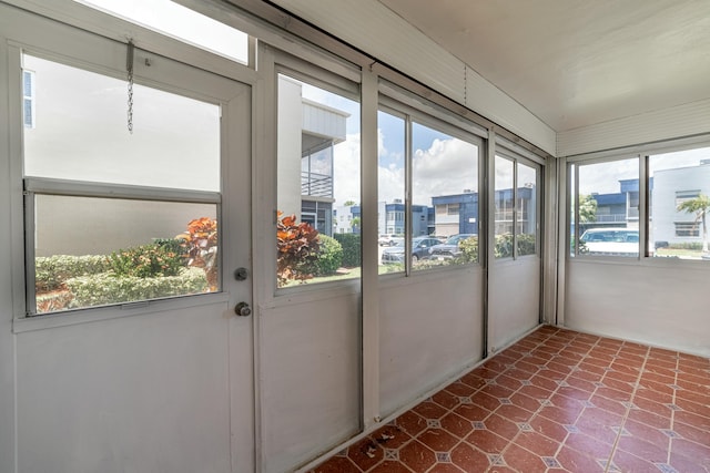 unfurnished sunroom with a view of city and a wealth of natural light