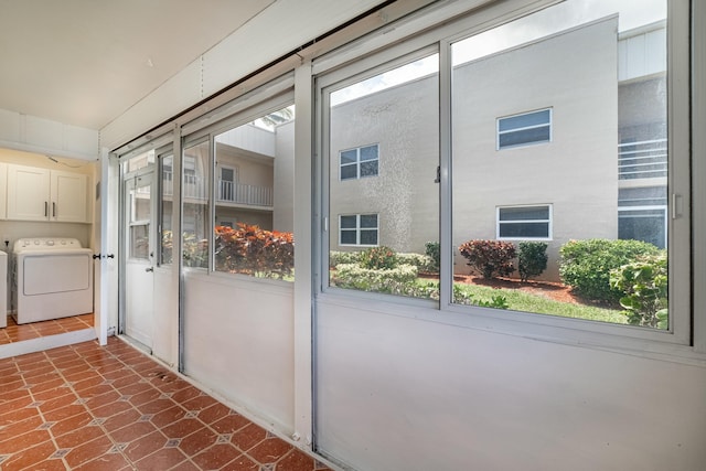 entryway featuring washer / dryer, dark tile patterned flooring, and a wealth of natural light