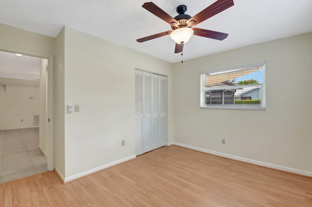 7140 Bobalink Ct, Lake Worth, FL 33467 - unfurnished bedroom featuring baseboards, wood finished floors, a textured ceiling, and a closet