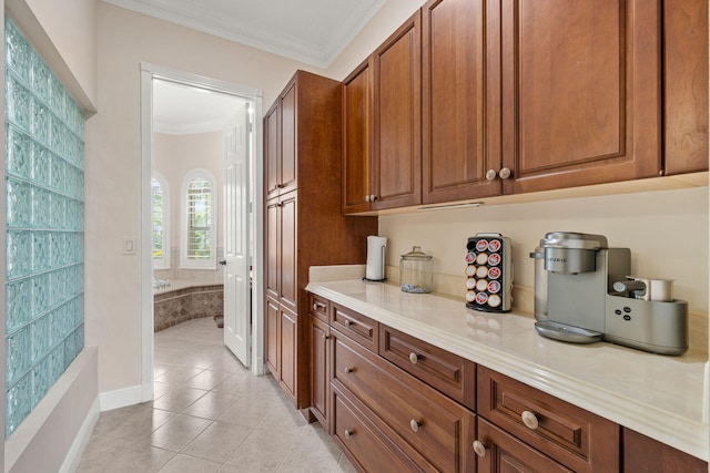 interior space with light tile patterned floors, brown cabinetry, light countertops, and ornamental molding