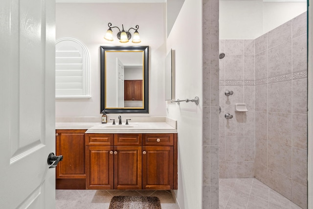 bathroom with tile patterned flooring, vanity, and tiled shower