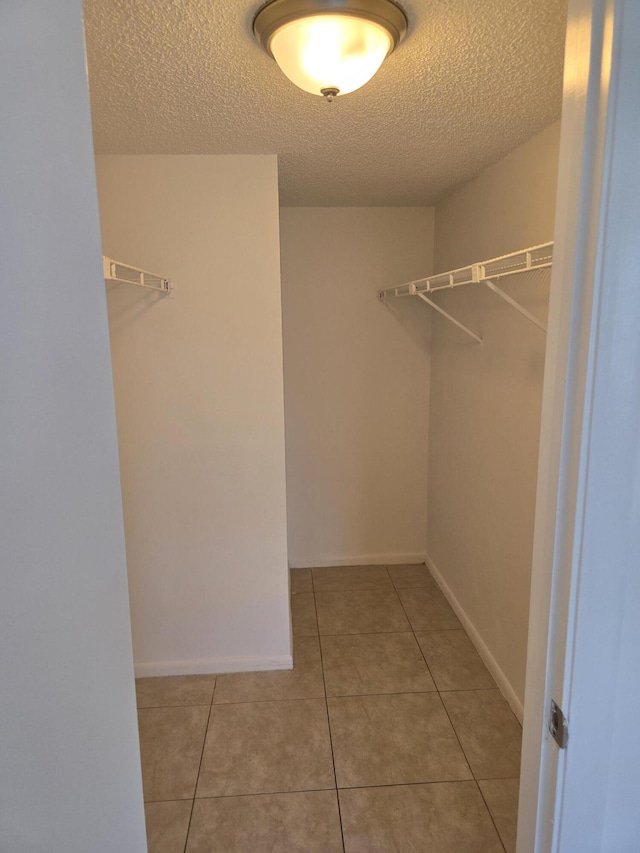 walk in closet with light tile patterned floors
